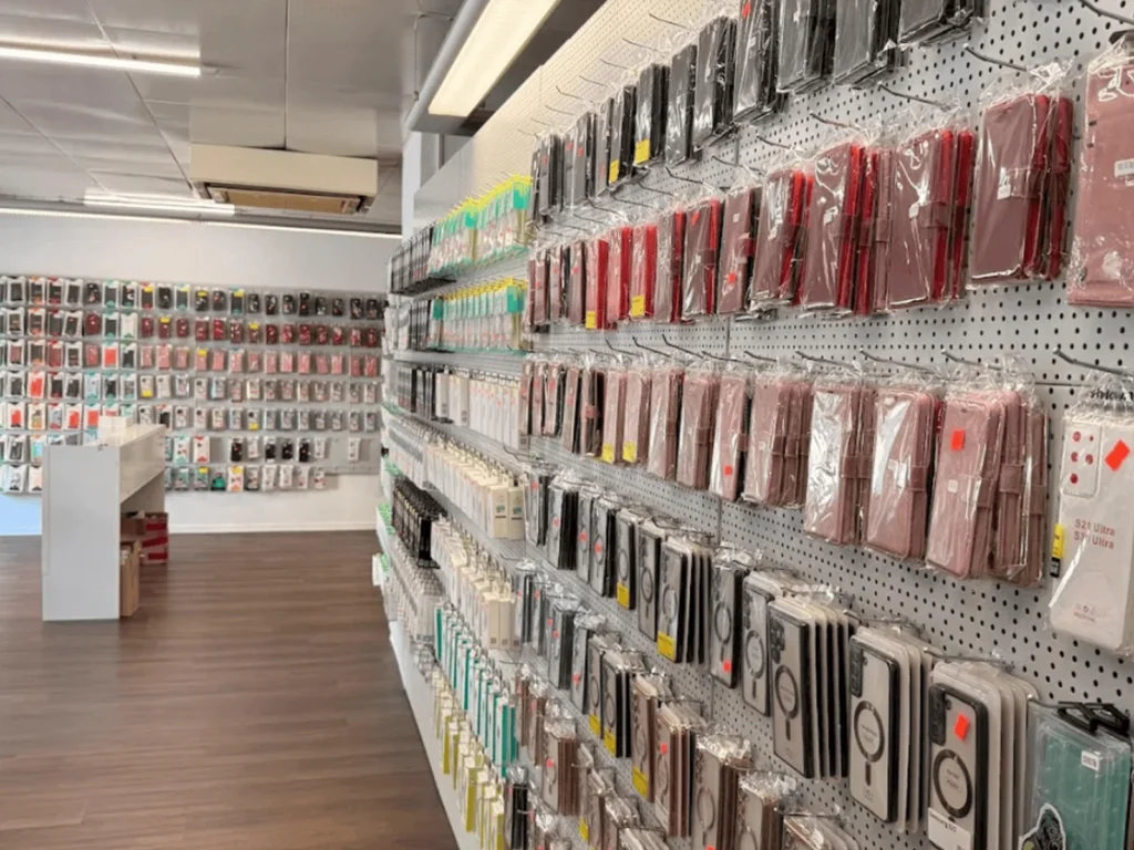 Innenansicht des phonezone Geschäfts in Amriswil mit hell erleuchteten Regalen voller Handyhüllen, Ladekabeln und übersichtlich gestalteten Produktdisplays.